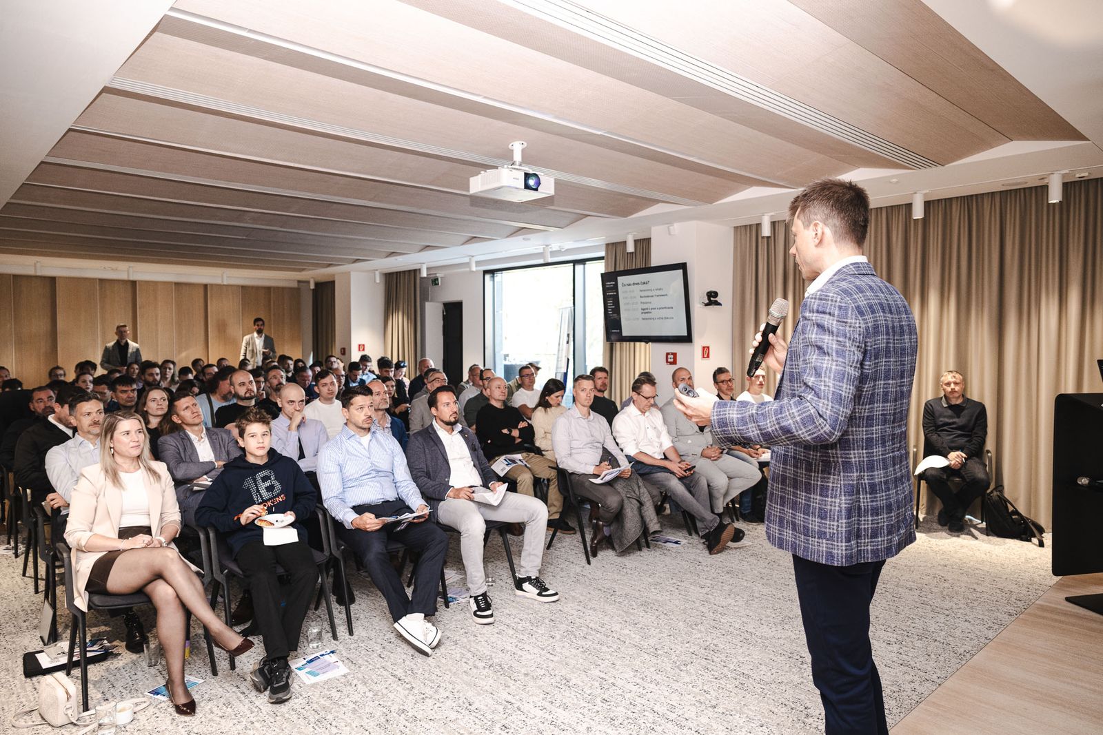 Michal Juhás speaking to a full room at an AI business breakfast in Bratislava